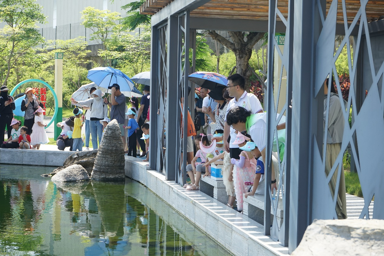 志愿者指引着小朋友和家长们参观污水净化的工艺