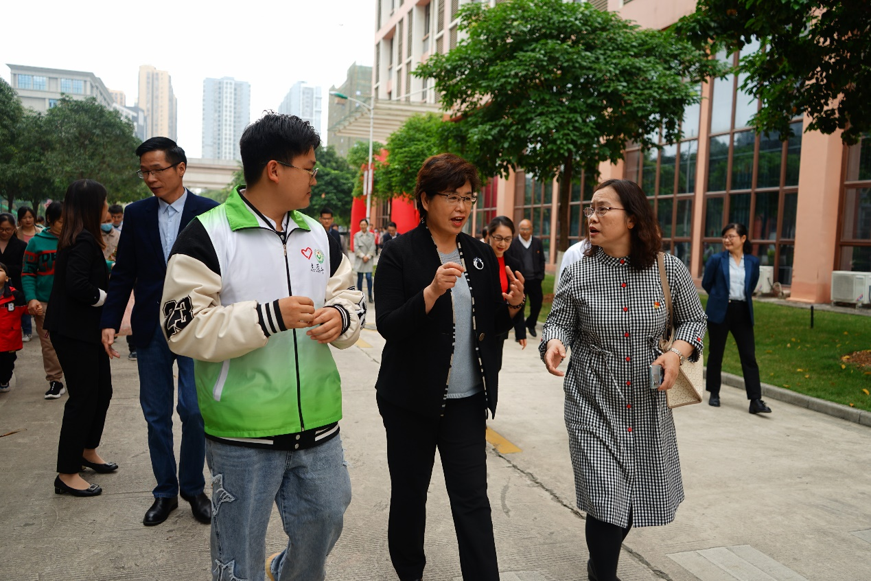 自治区残联党组书记、理事长黄丽娟（中）与伟德国际1946源于英国设备学院党总支书记侯文淑（右）对活动进行深入沟通交流